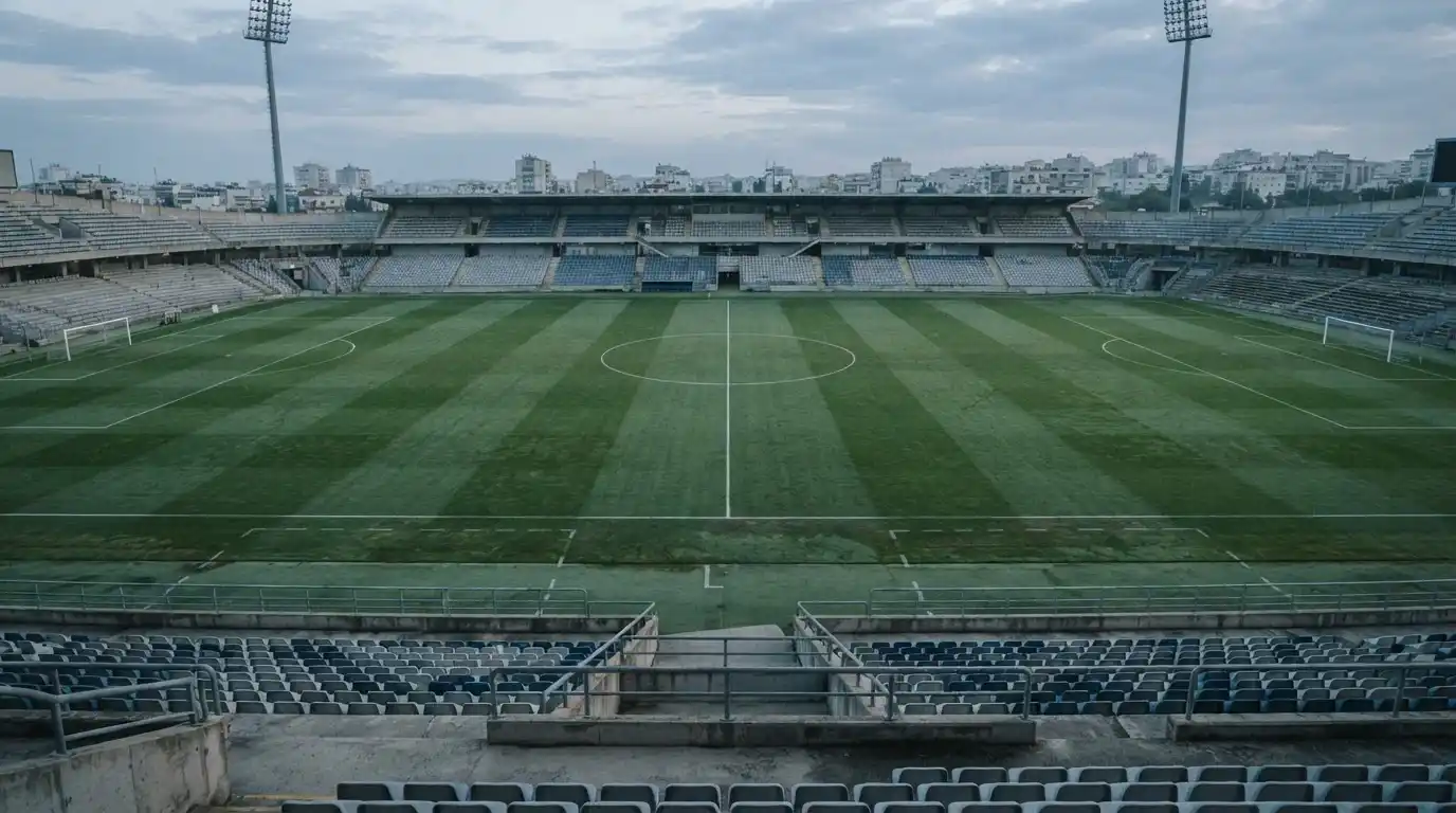 Campo de fútbol vacío al amanecer con la línea del centro dividiendo el césped